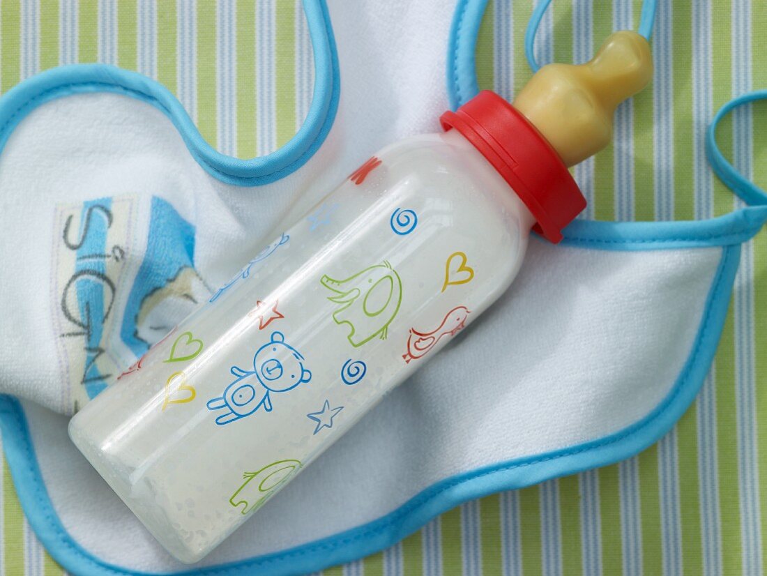 A mandarine baby food drink in a baby bottle