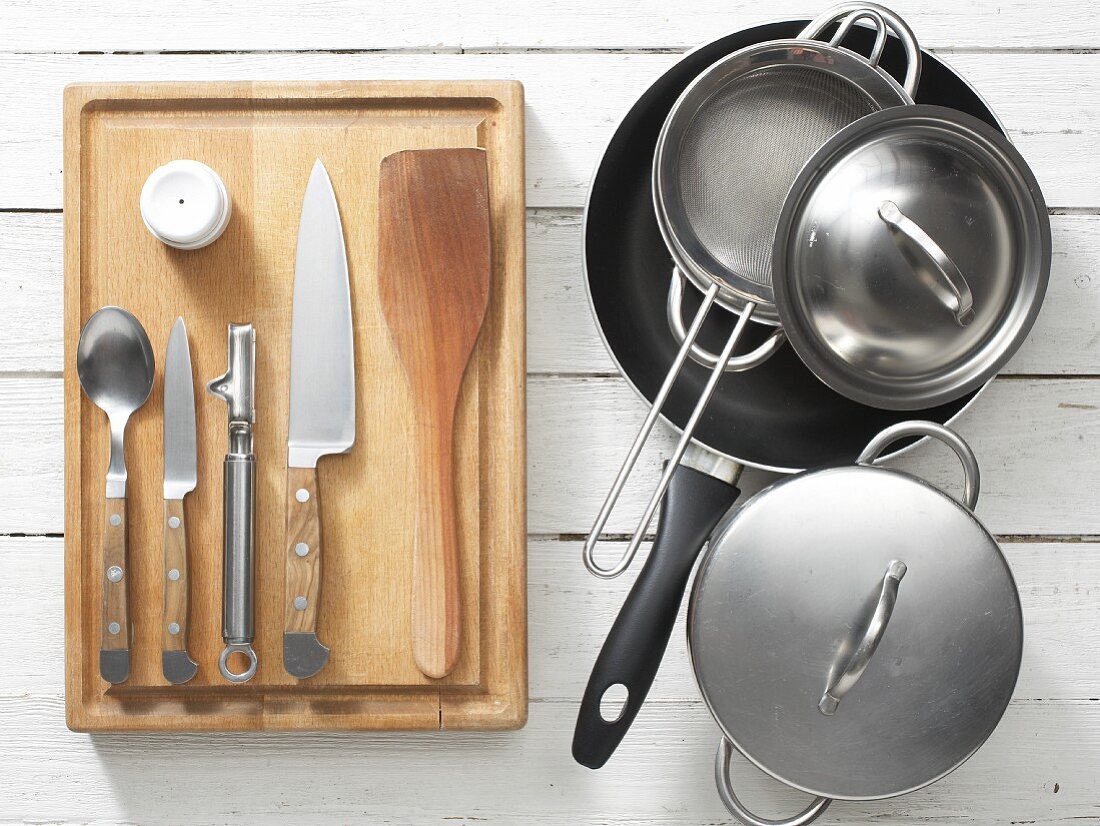 Assorted kitchen utensils: saucepans, a frying pan, an egg pricker and a knife