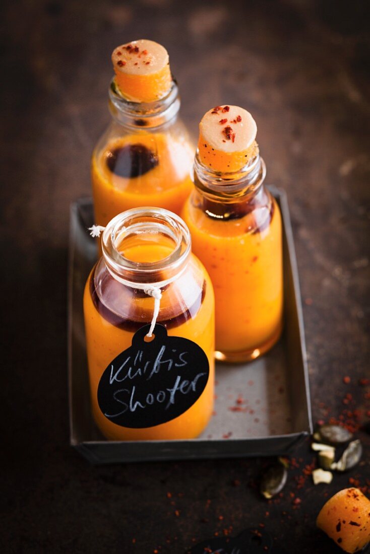 Vegan pumpkin shots with chilli flakes in small glass bottles