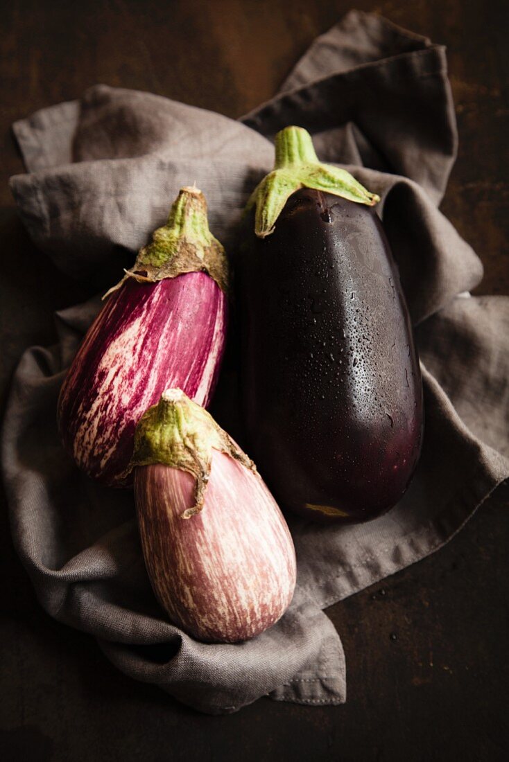 Various aubergines on a dark cloth