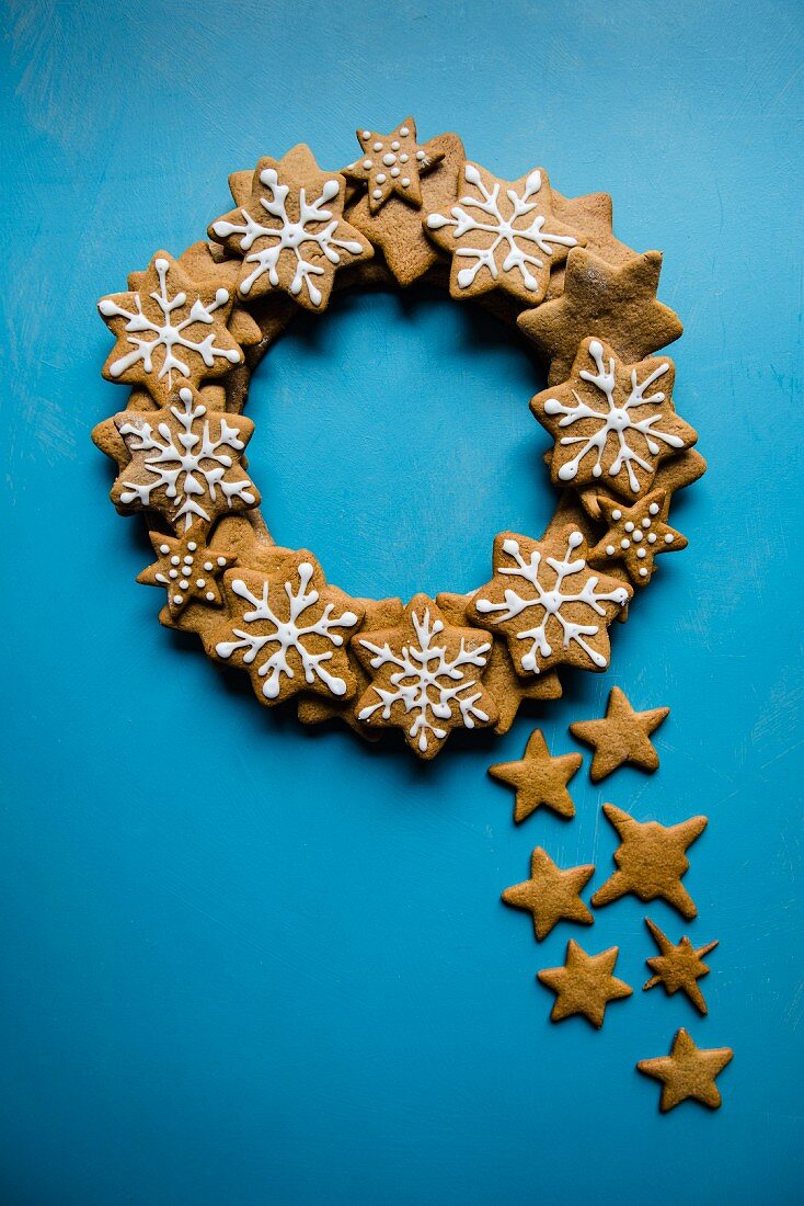 A wreath made of iced gingerbread stars on a blue background