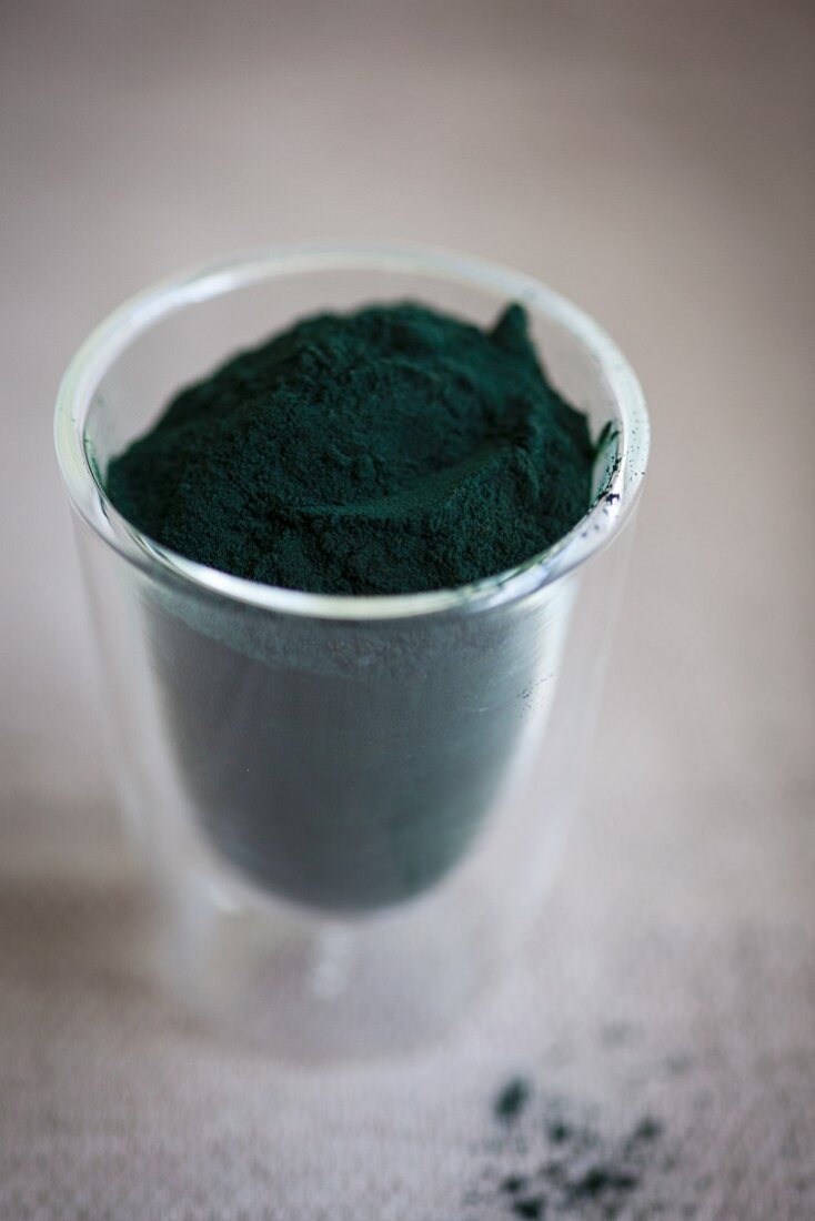 Spirulina powder in a glass cup