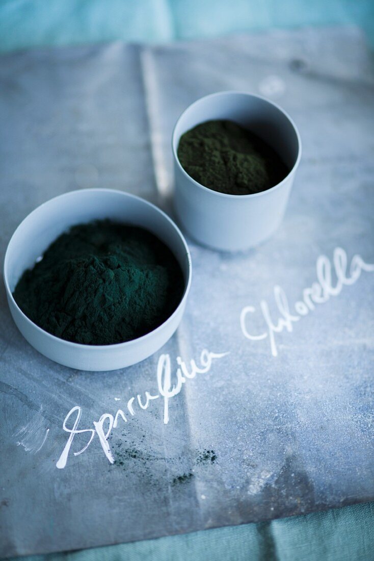 Spirulina and chlorella powder in small bowls