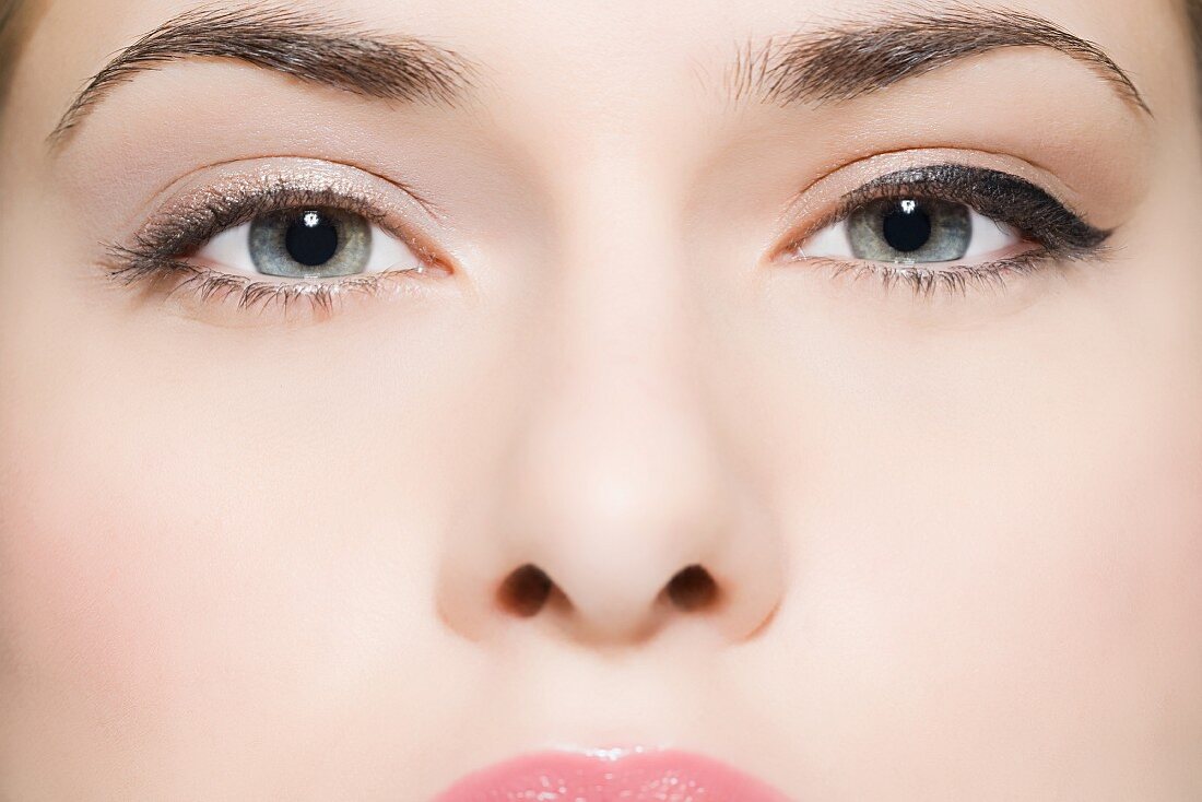 The face of a young woman with eyes featuring different make-up styles