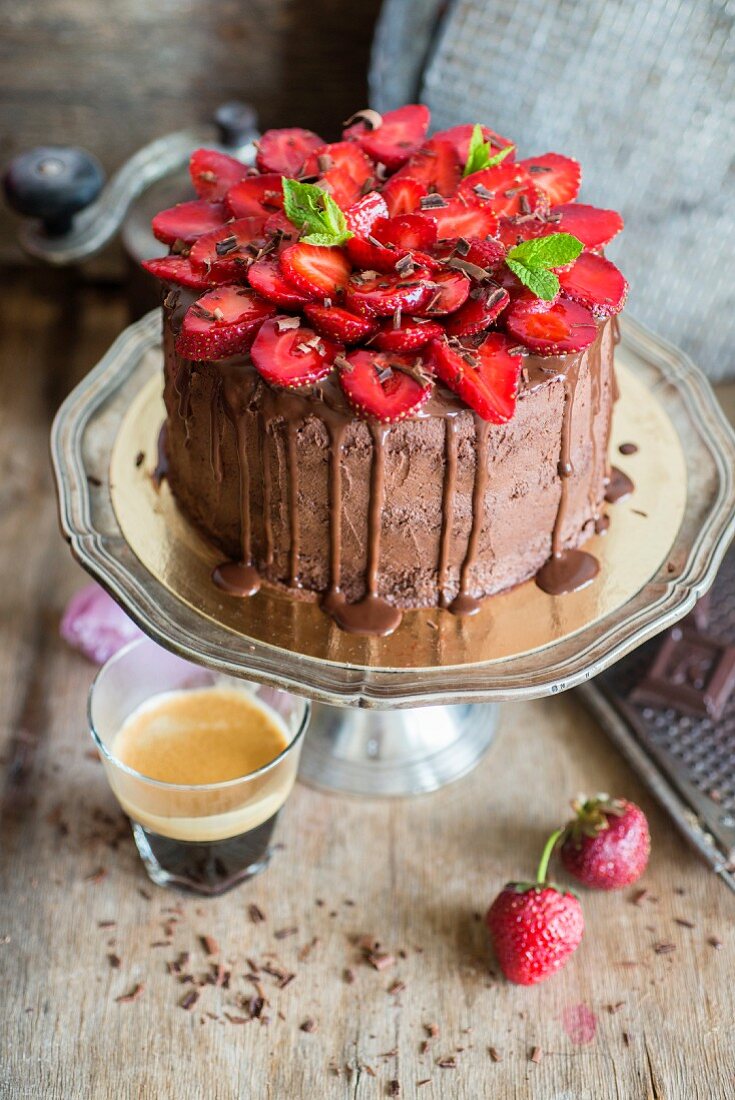 A chocolate cake with chocolate icing and sliced strawberries