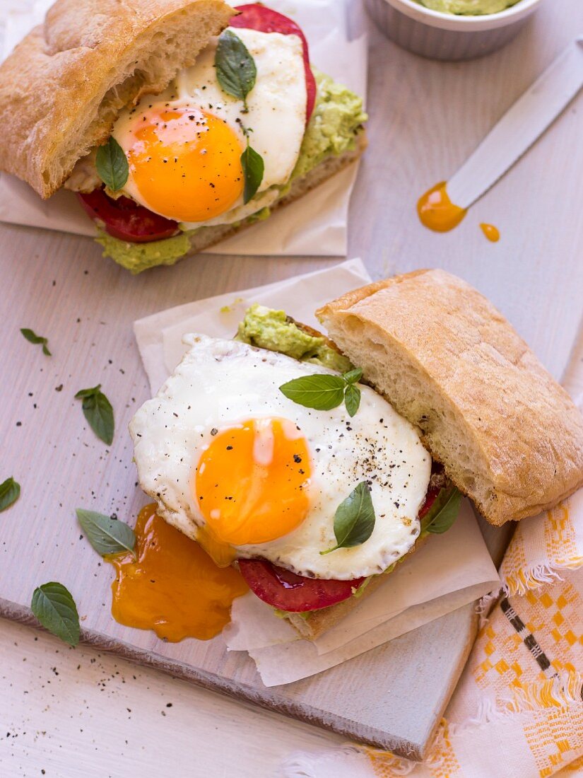 A sandwich with broad bean & feta spread, tomatoes and fried egg