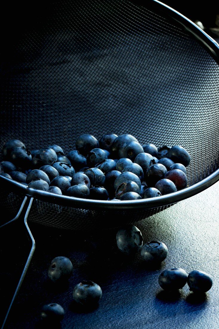 Blueberries in a black metal sieve