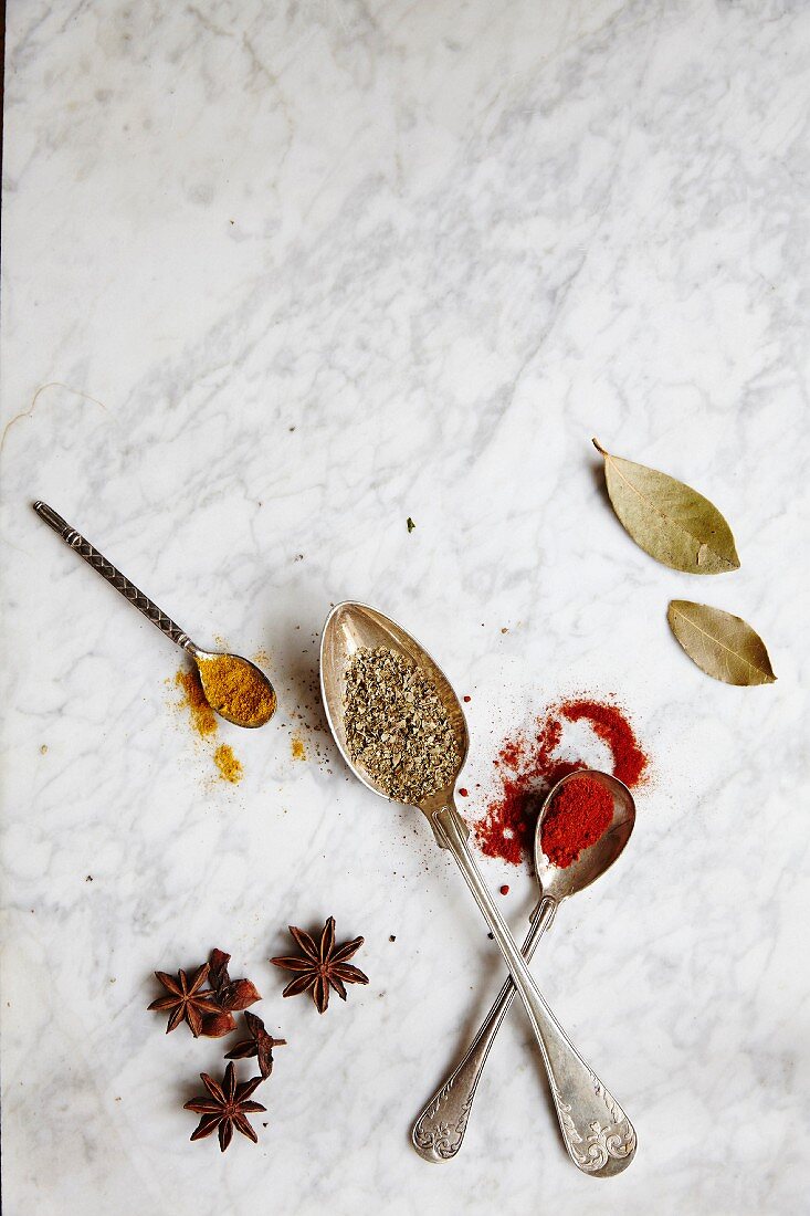 Spoons with assorted spices on a marble background