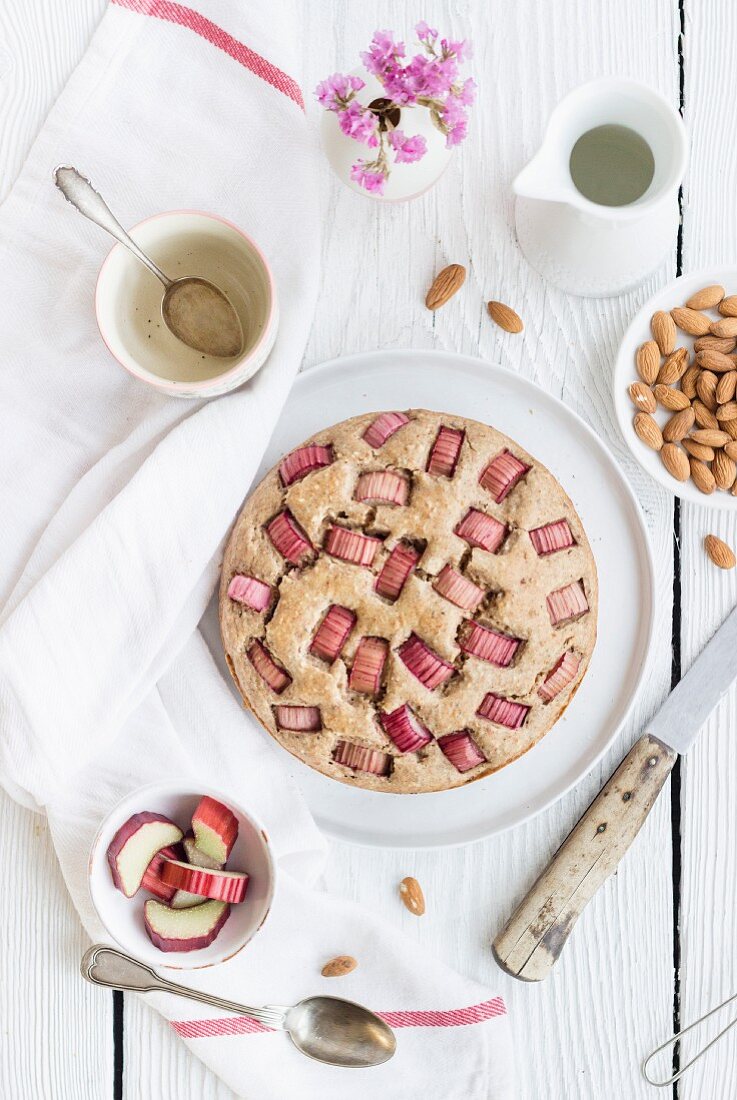 A whole rhubarb cake with almonds on a table