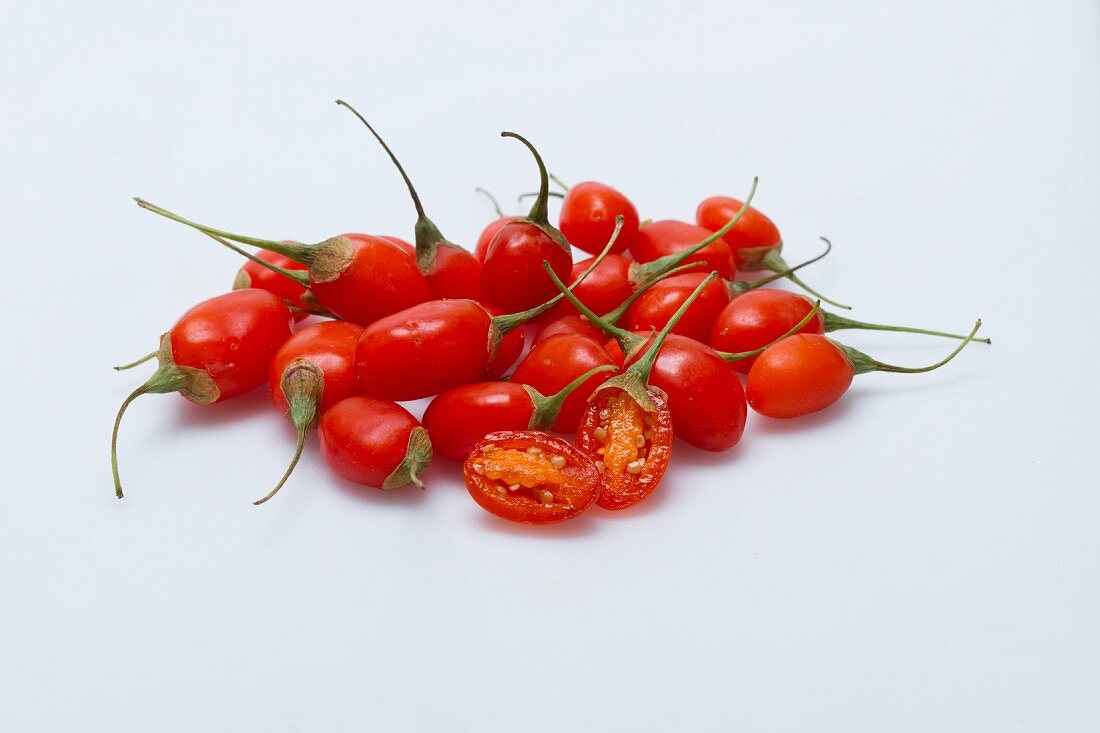 A pile of fresh goji berries on a white surface