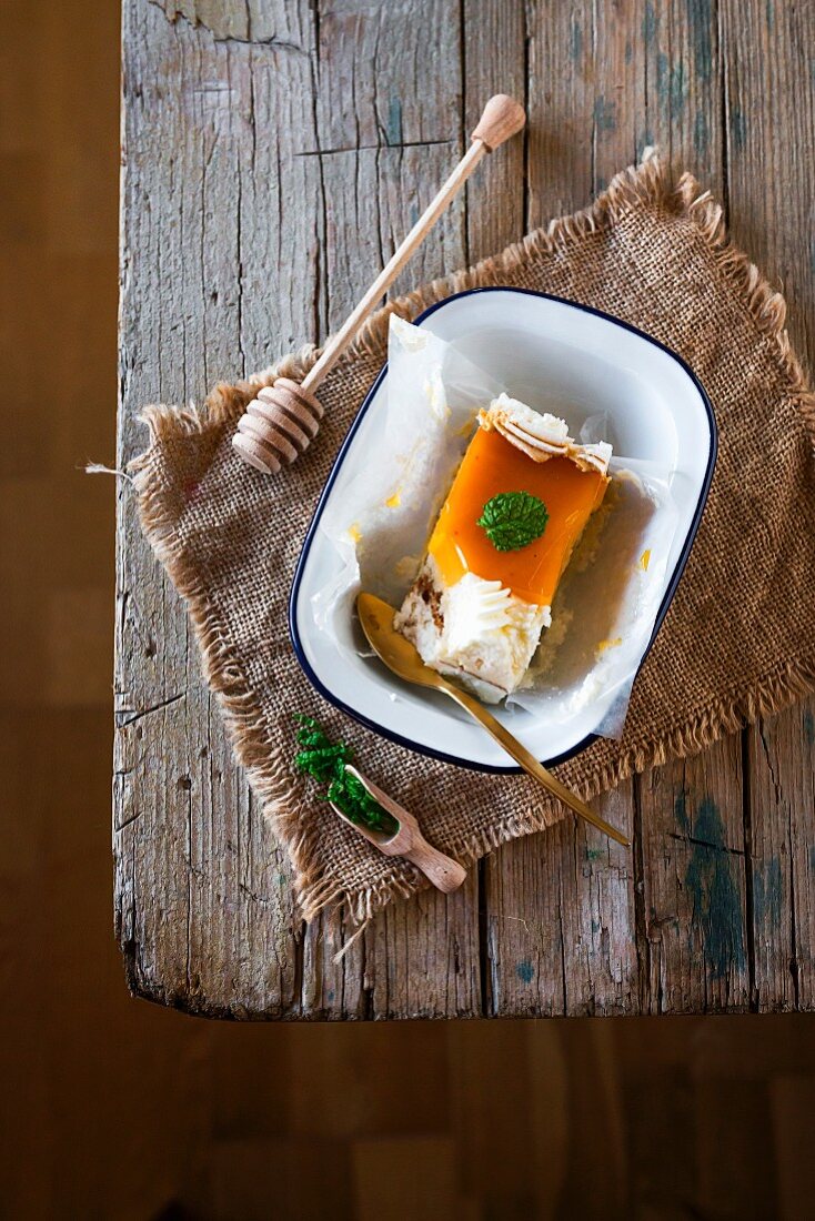 A slice of toasted egg yolk cake with cream and mint