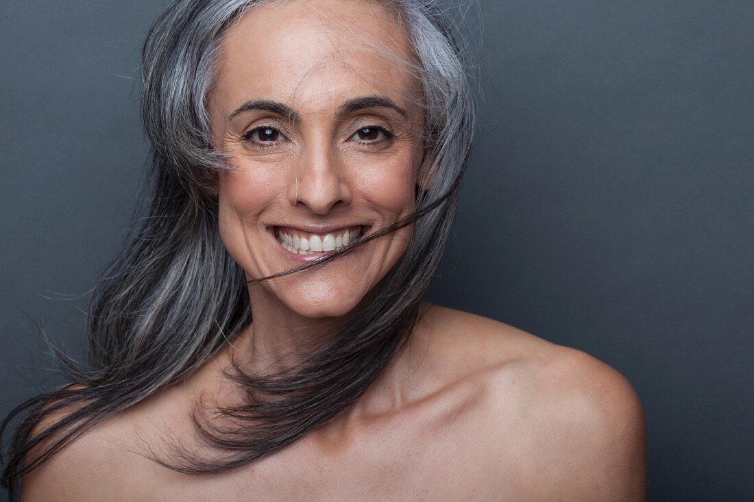 A portrait of an older woman with flowing grey hair