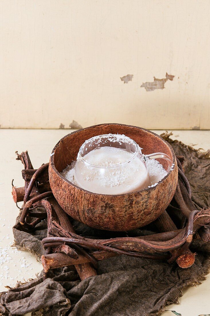Kokomilchshake mit Kaffee in Glastasse und Kokosnusshälfte serviert