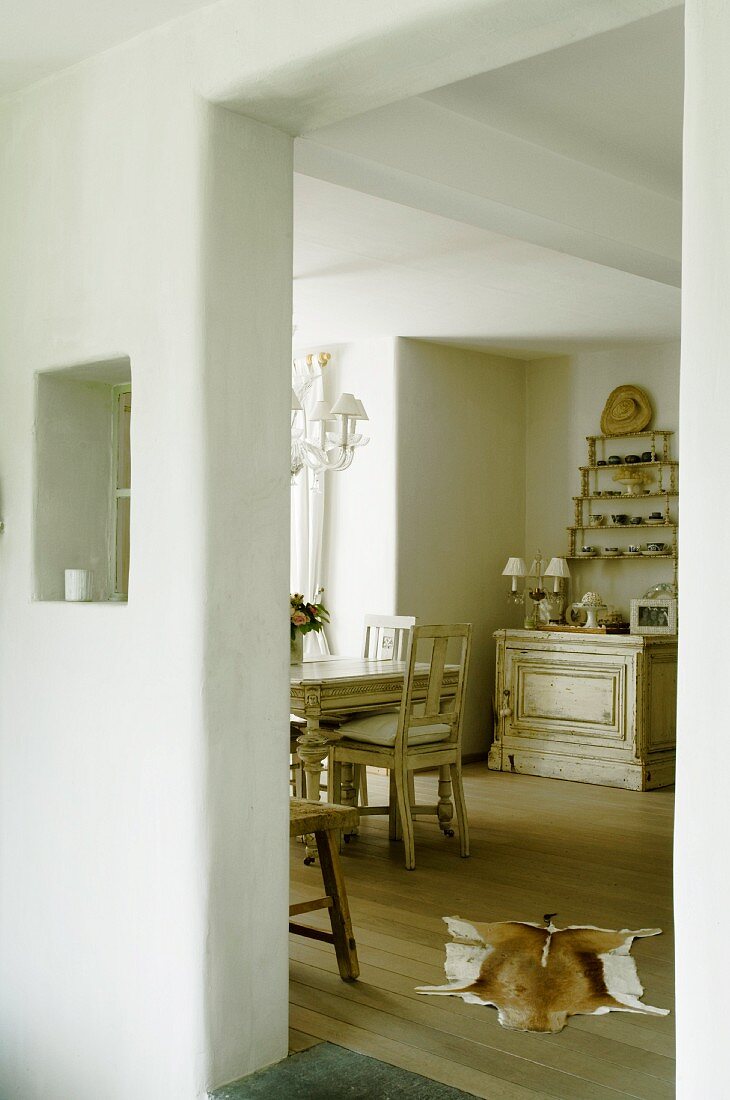 Einblick in Essbereich mit Dielenboden und Tierfellvorleger in renoviertem Landhaus