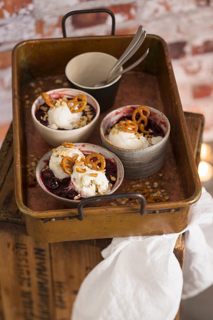 Caramel ice cream with cherry compote and salty pretzel-shaped biscuits