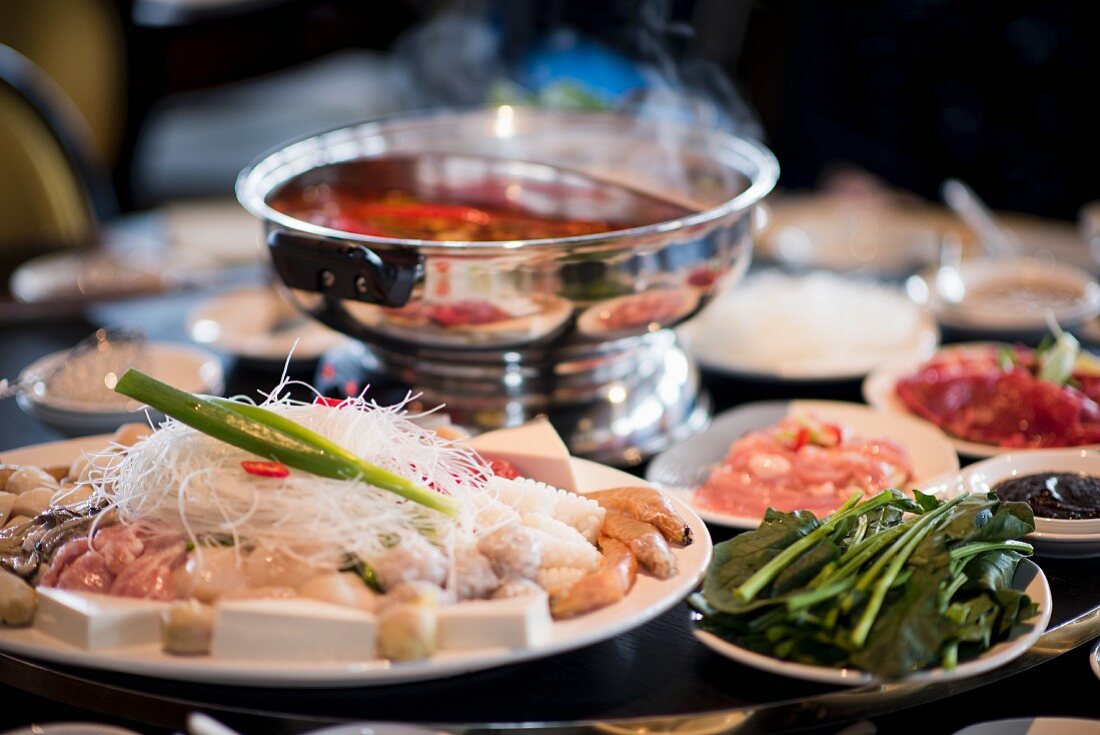 A table full of ingredients for a Chinese fondue (Asia)