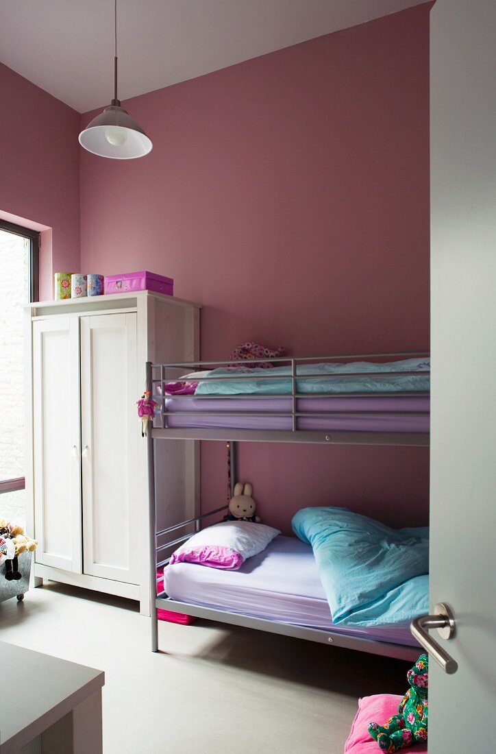 Kinderzimmer mit Hochbett und rosafarbenen Wänden