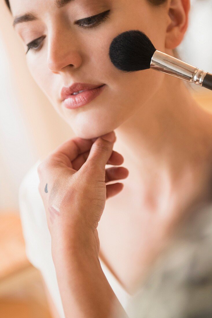 A woman having make-up applied by stylist