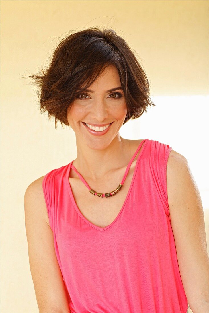 A brunette woman in a pink-coloured top