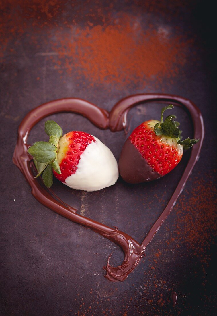 Strawberries dipped in chocolate framed by a melted chocolate heart