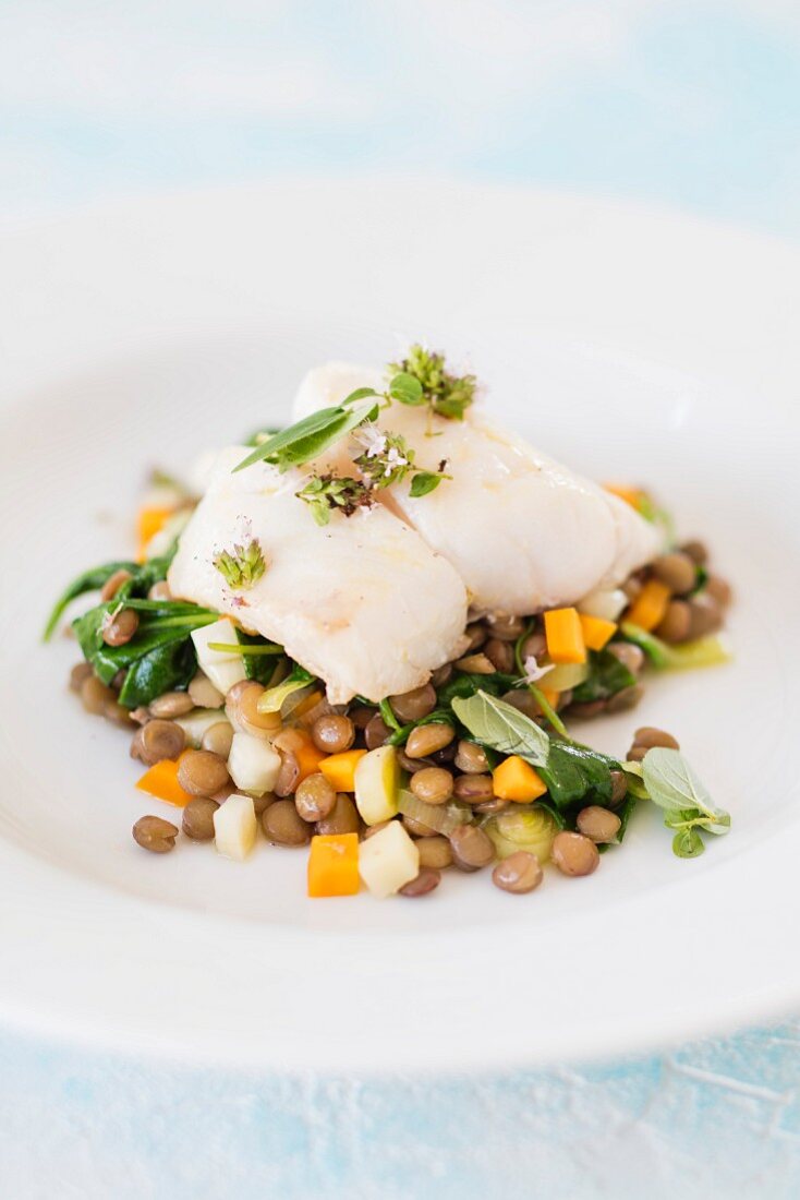 Fillet of coalfish with oregano on a bed of lentils and vegetables (low-carb)