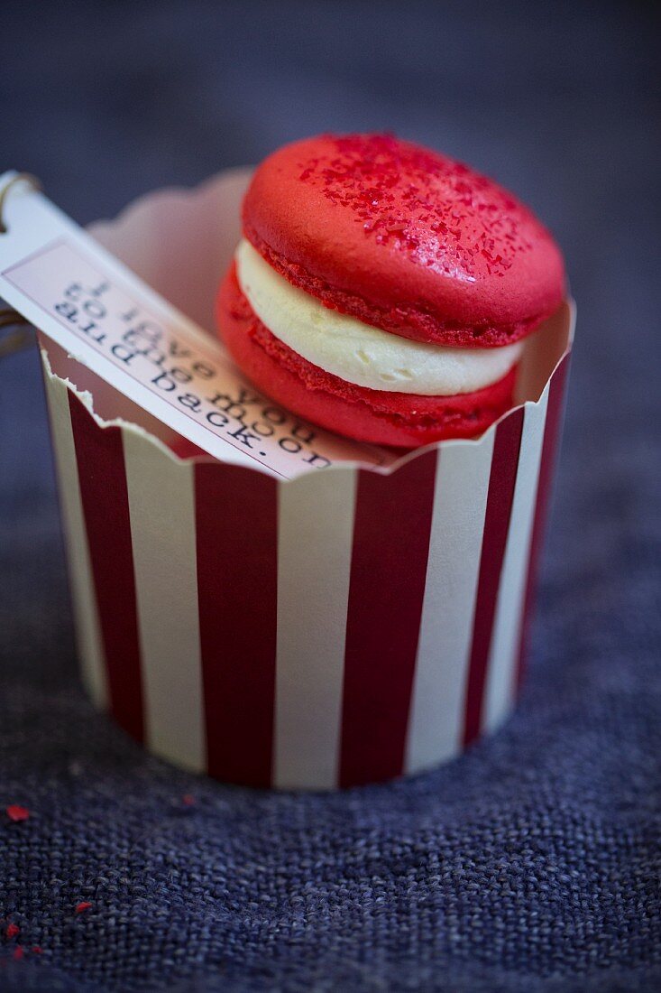 A red macaron with a gift tag and romatic message for Valentine's Day