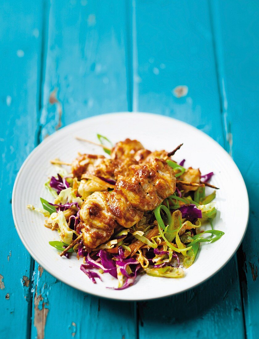 Spicy chicken kebabs on a bed of cabbage salad