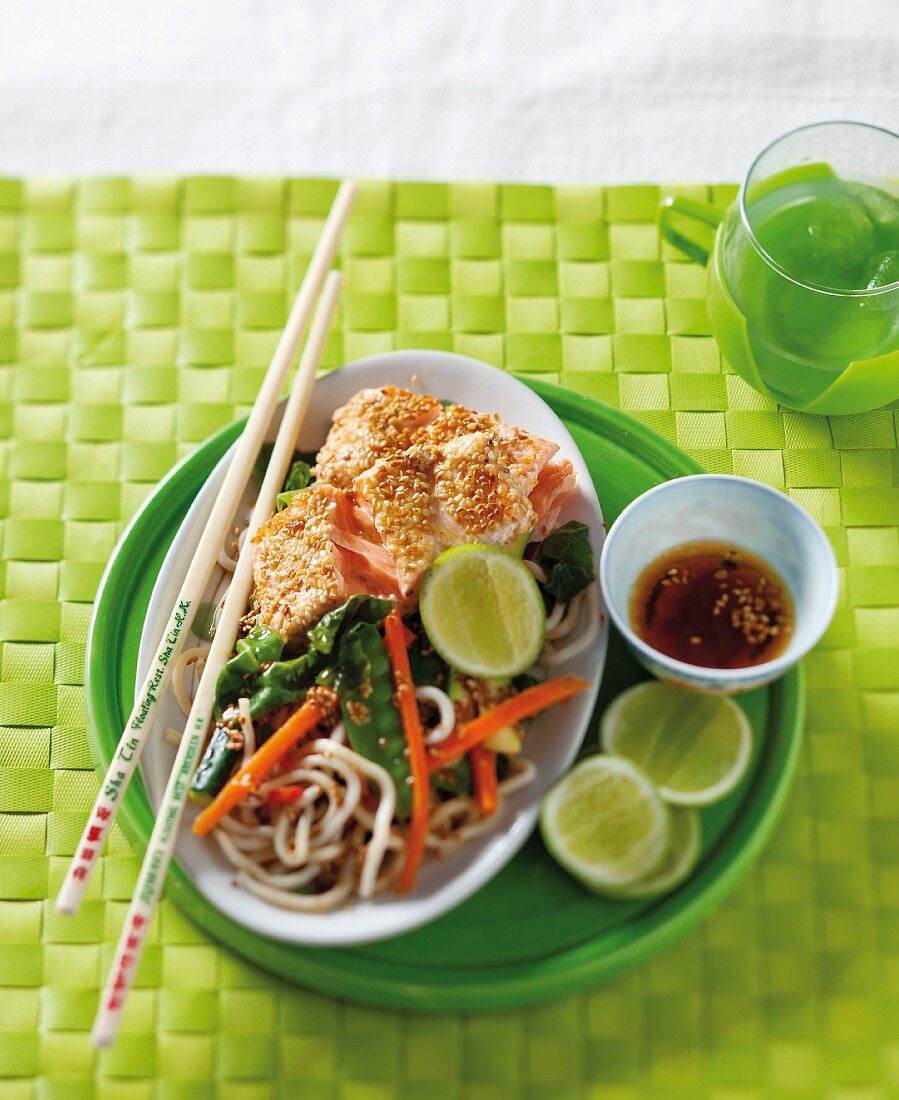 Salmon with a sesame seed coating served with noodles and vegetables