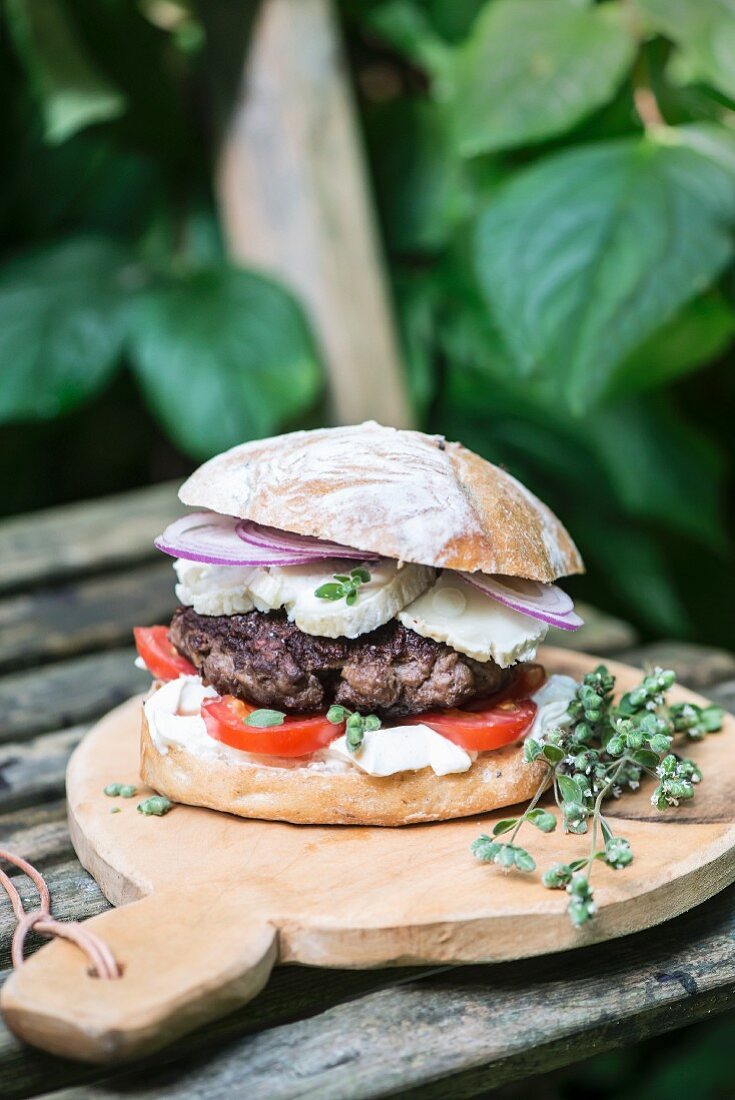 A lamb burger with goats' cheese, red onions, thyme and tomato
