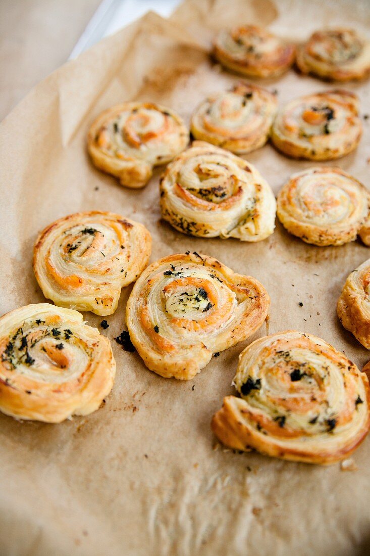 Freshly baked salmon puff pastry swirls on a baking sheet