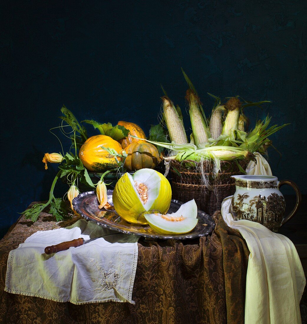 An autumnal arrangement with melons, pumpkins and sweetcorn