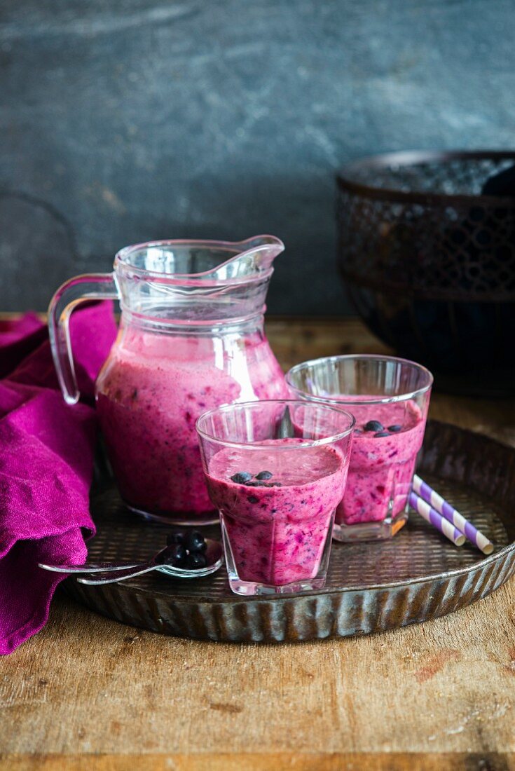 Blueberry smoothie in a jug and glasses