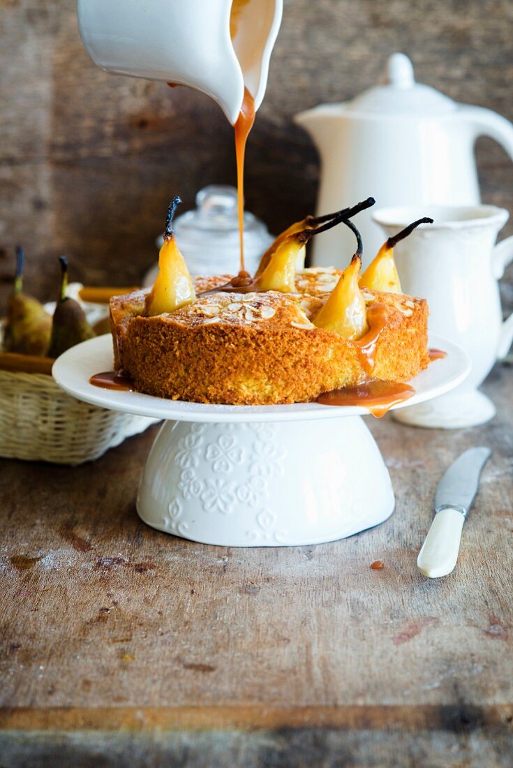 Vanilla cake with poached pears, flaked almonds and caramel sauce