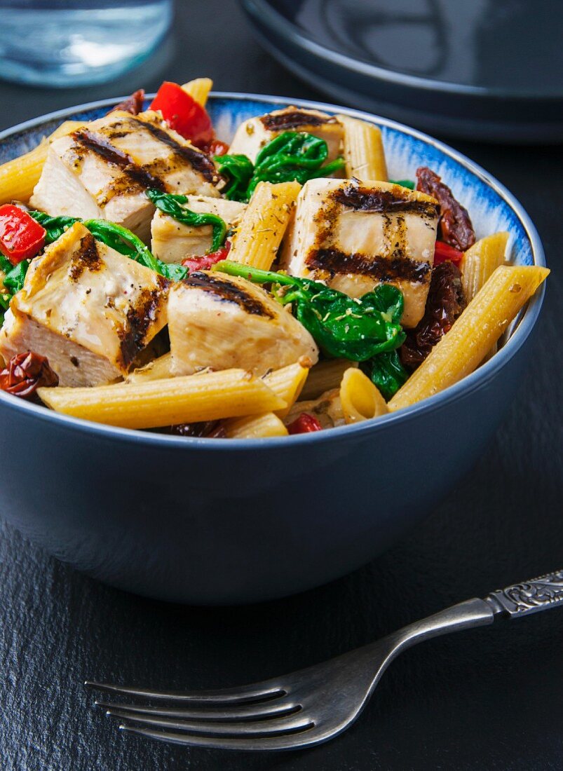 Wholemeal penne pasta with grilled chicken, pepper and spinach