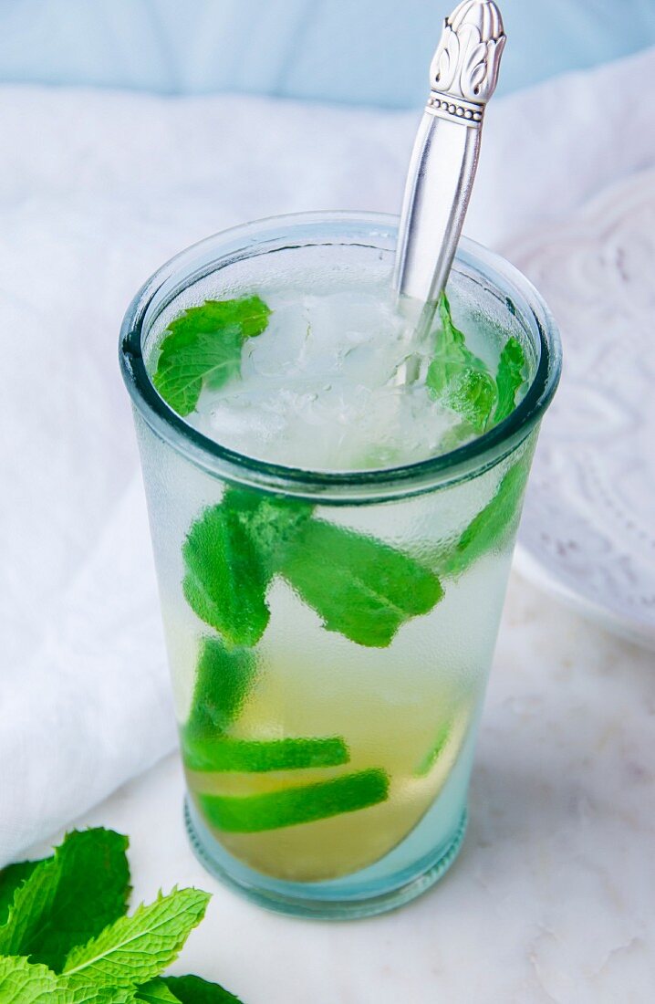 A Mojito cocktail with lime and mint in a chilled glass