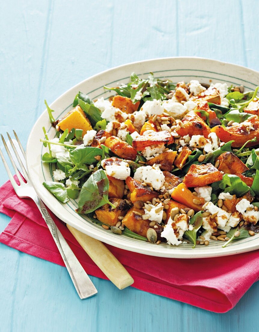 A miexd salad with roasted butternut squash, rocket, feta cheese and grains