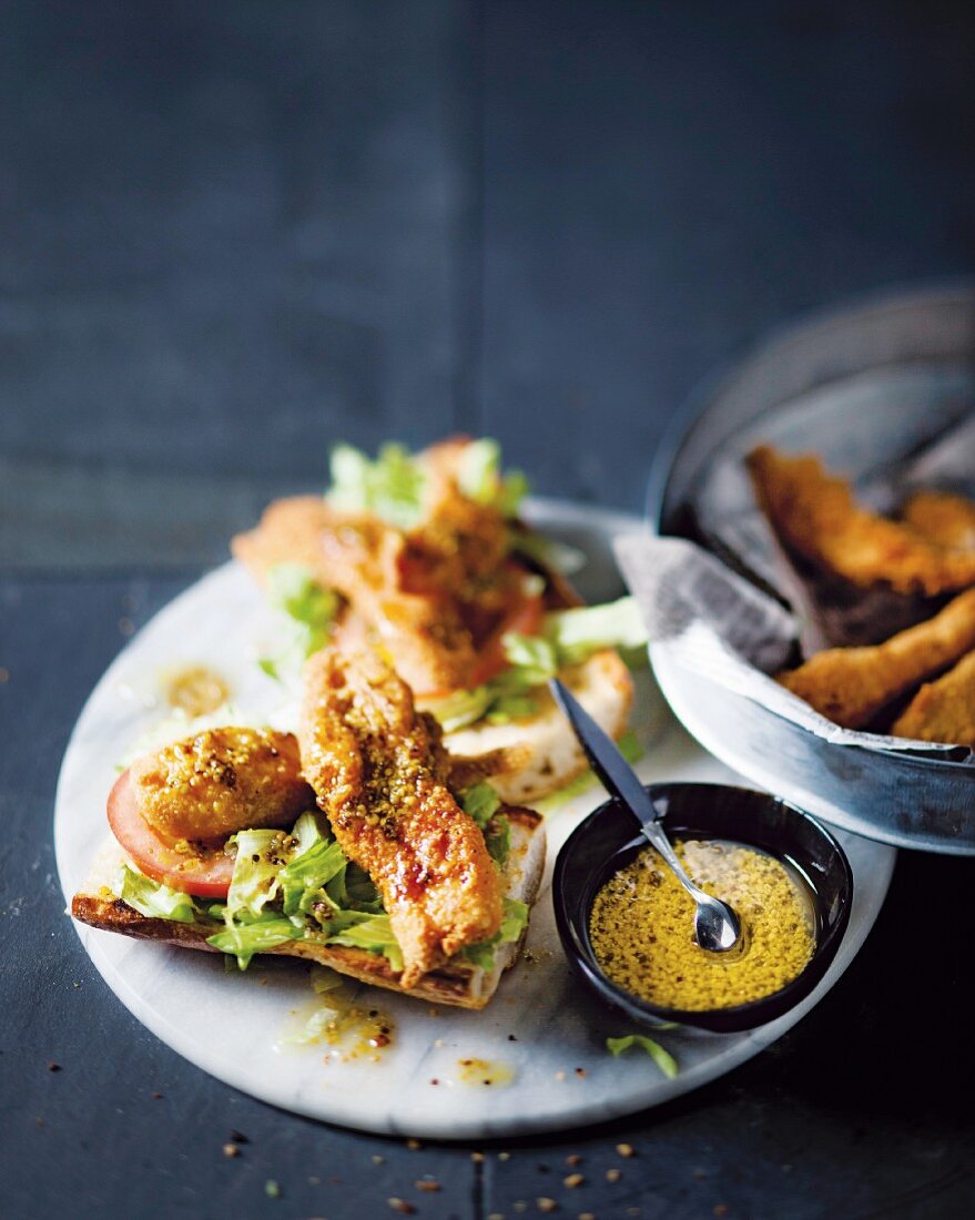 Chicken fillets with an almond coating on baguette halves with honey & mustard dressing