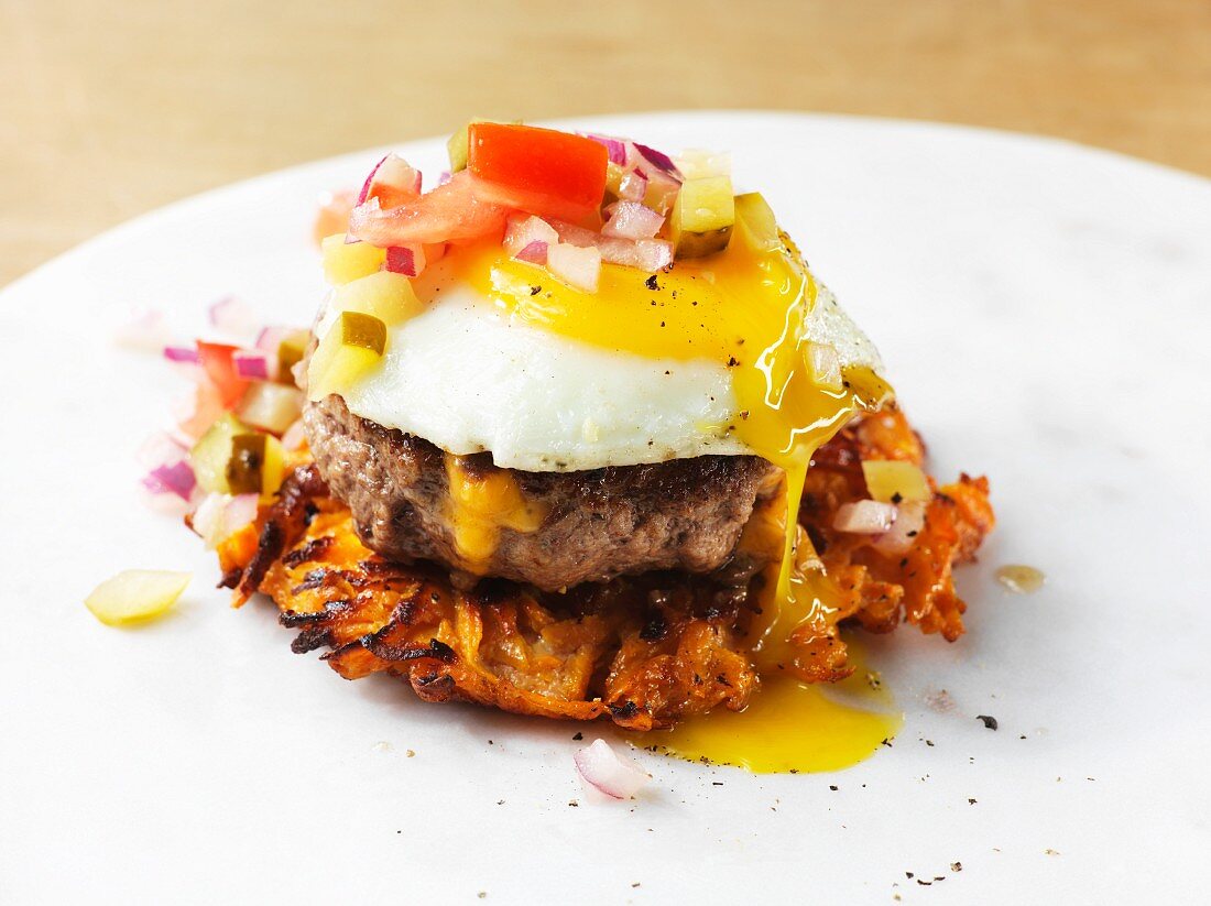 A burger without a bun and with a potato fritter, minced beef and an egg