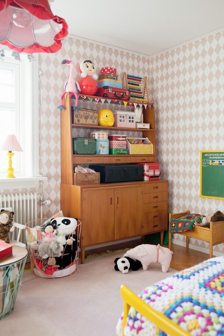 Retro Schrank in Mädchenzimmer mit verschiedenen Köfferchen, Spielzeug und Plüschtieren