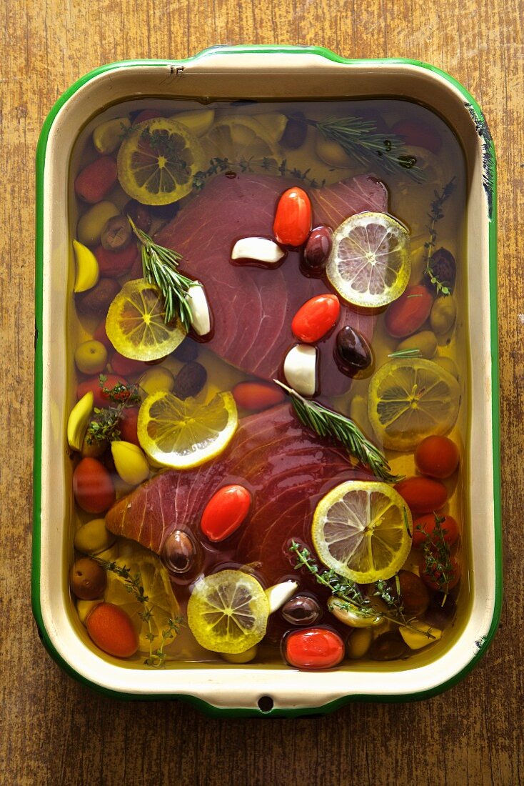 Tuna poached in olive oil with lemon, garlic and olives