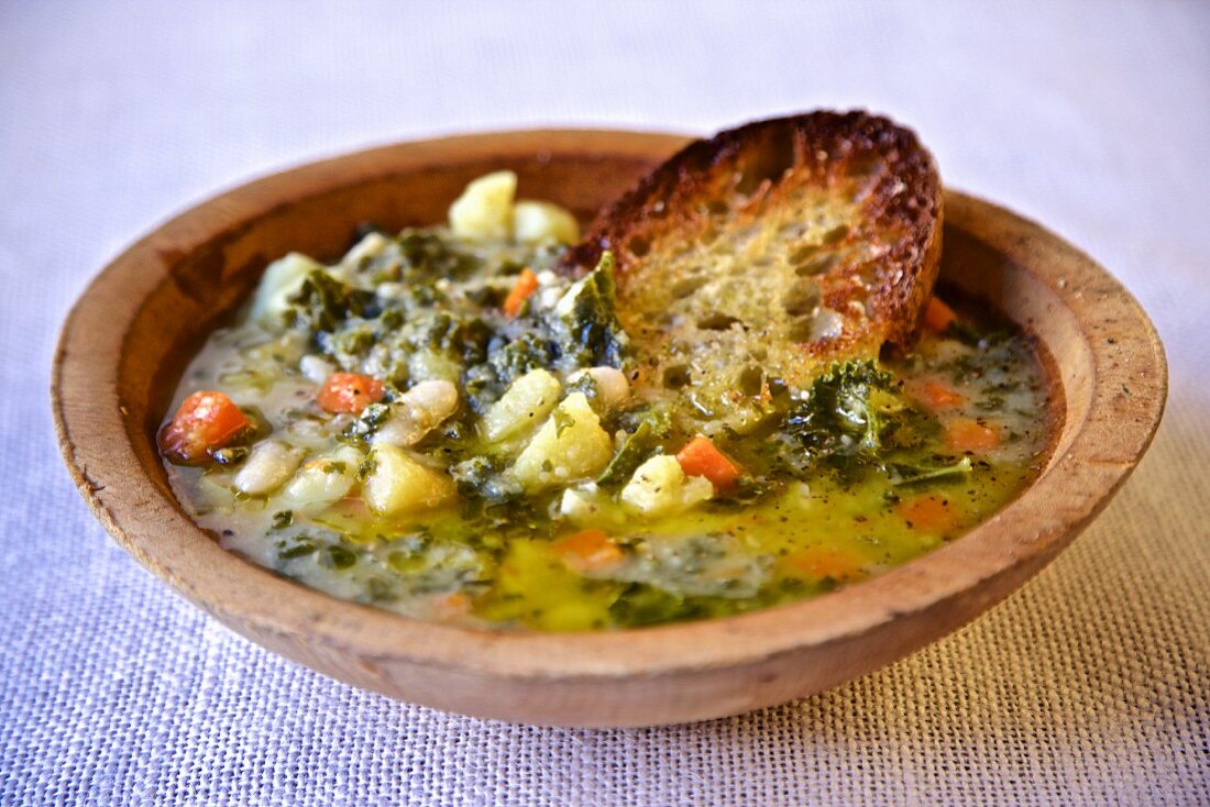 Tuscan vegetable soup with olive oil and toasted bread