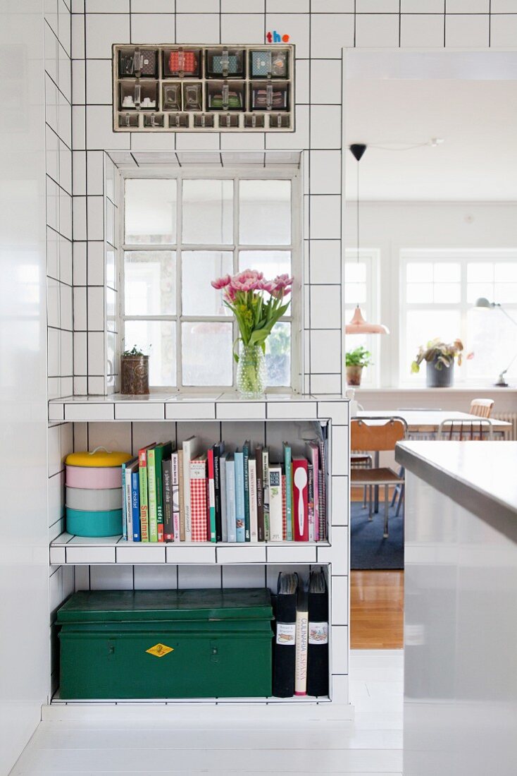 White wall tiles, interior window and open-fronted fitted shelves in kitchen