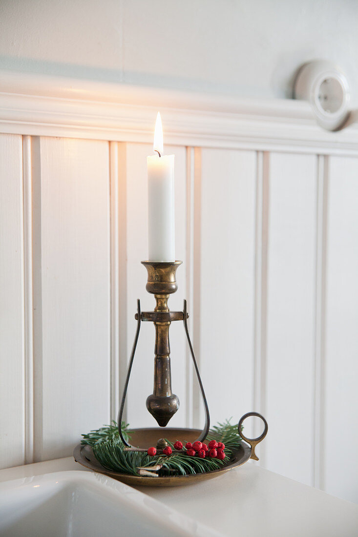 Antique candlestick decorated with fir sprigs and berries