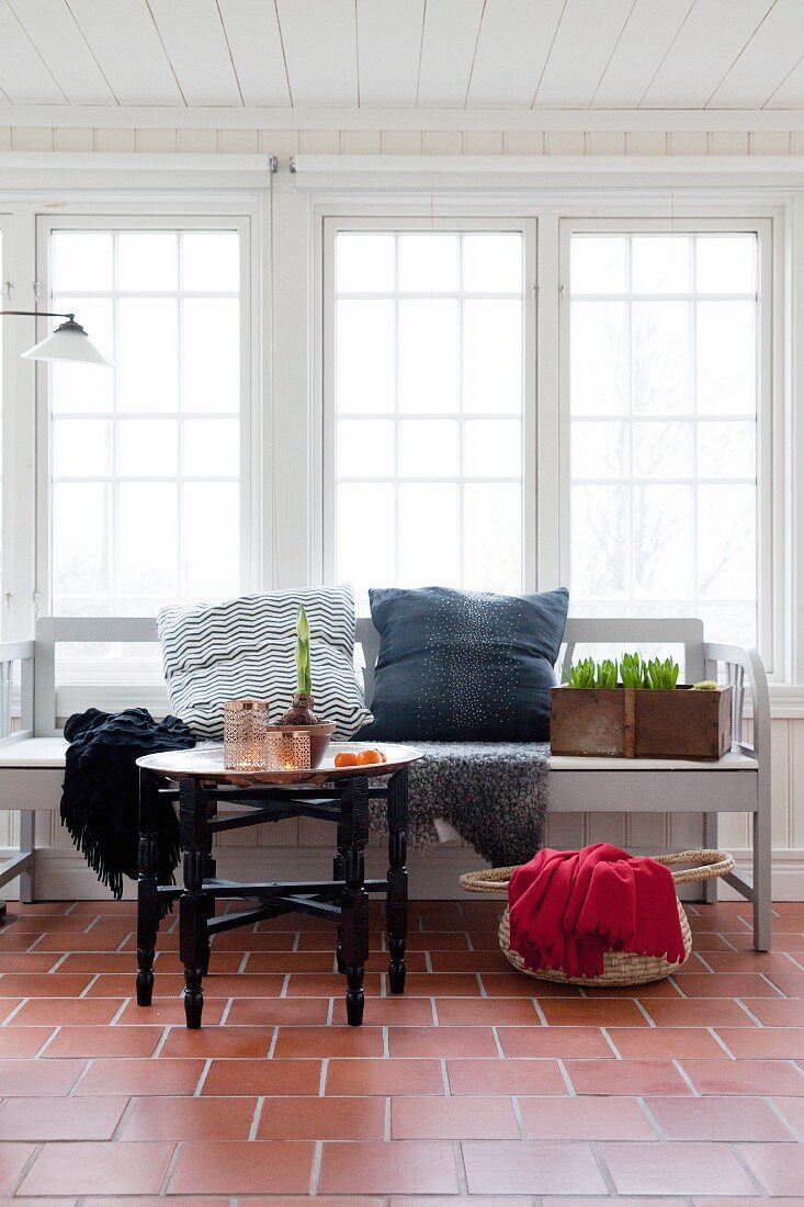 Oriental tray table in front of wooden bench in conservatory