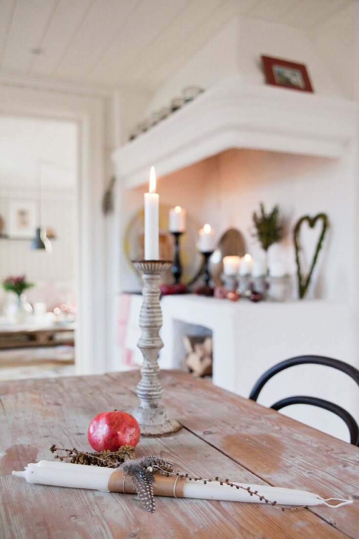 Lit candle an natural decorations on kitchen table