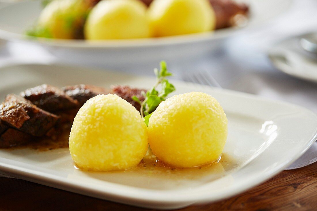 Potato dumplings as a side dish served with roast goose