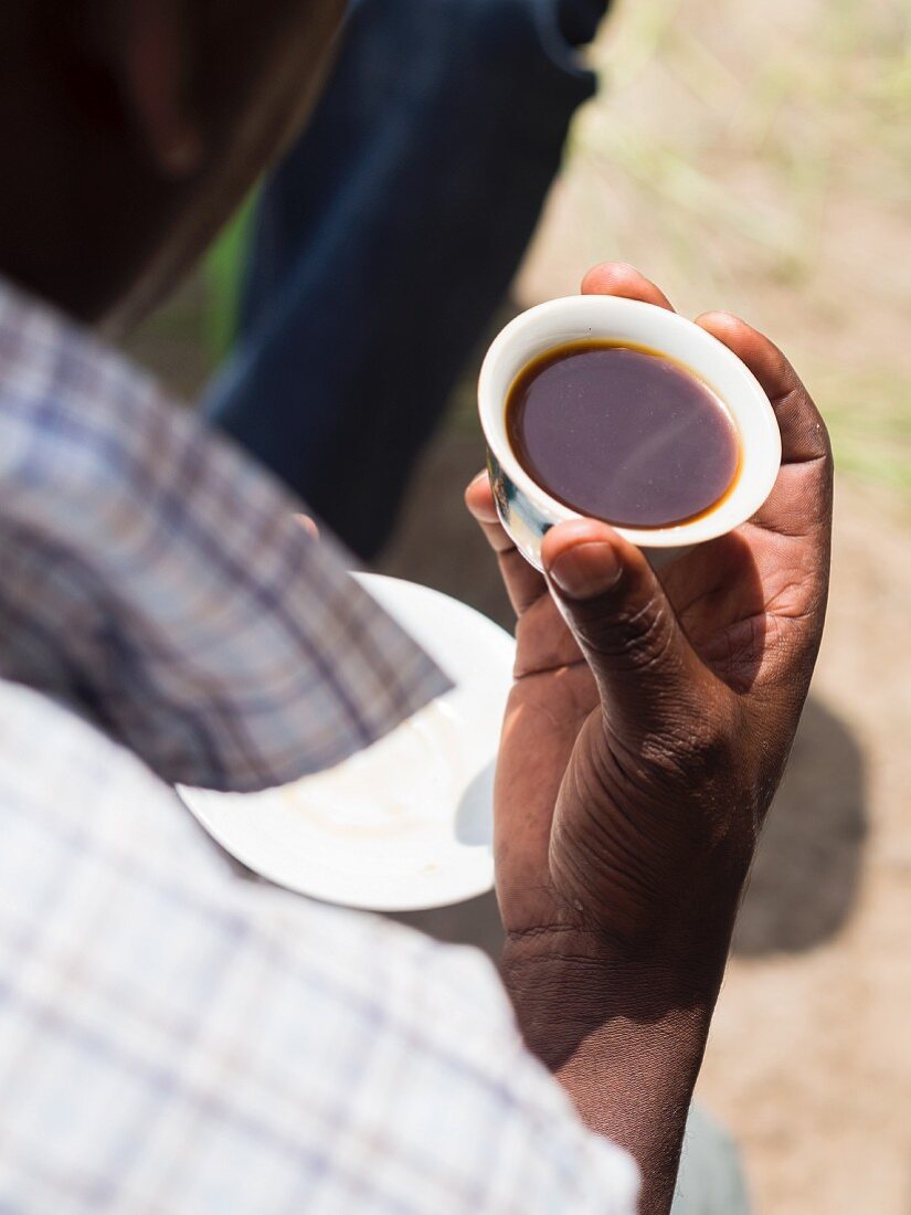 Mann hält eine Tasse äthiopischen Kaffee, traditionelle Kaffeezeremonie in Äthiopien