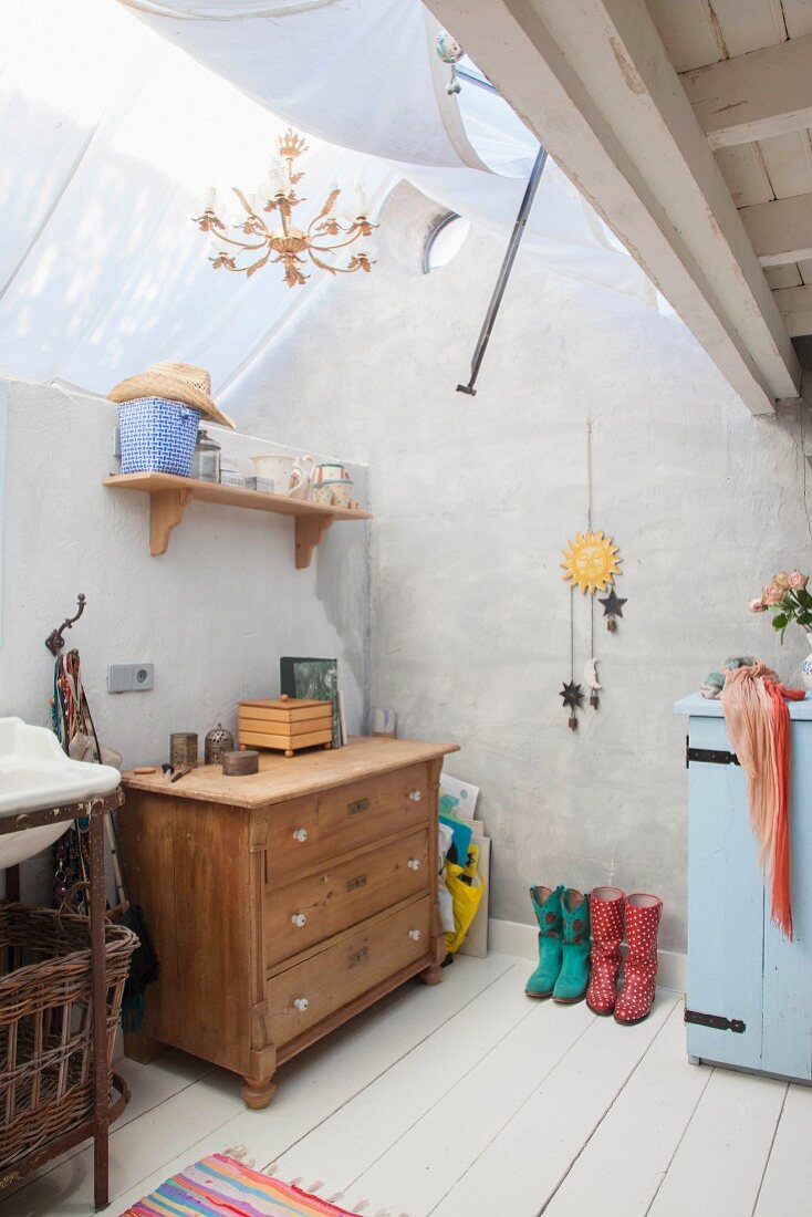 Chest of drawers and wall-mounted shelf under white fabric canopy