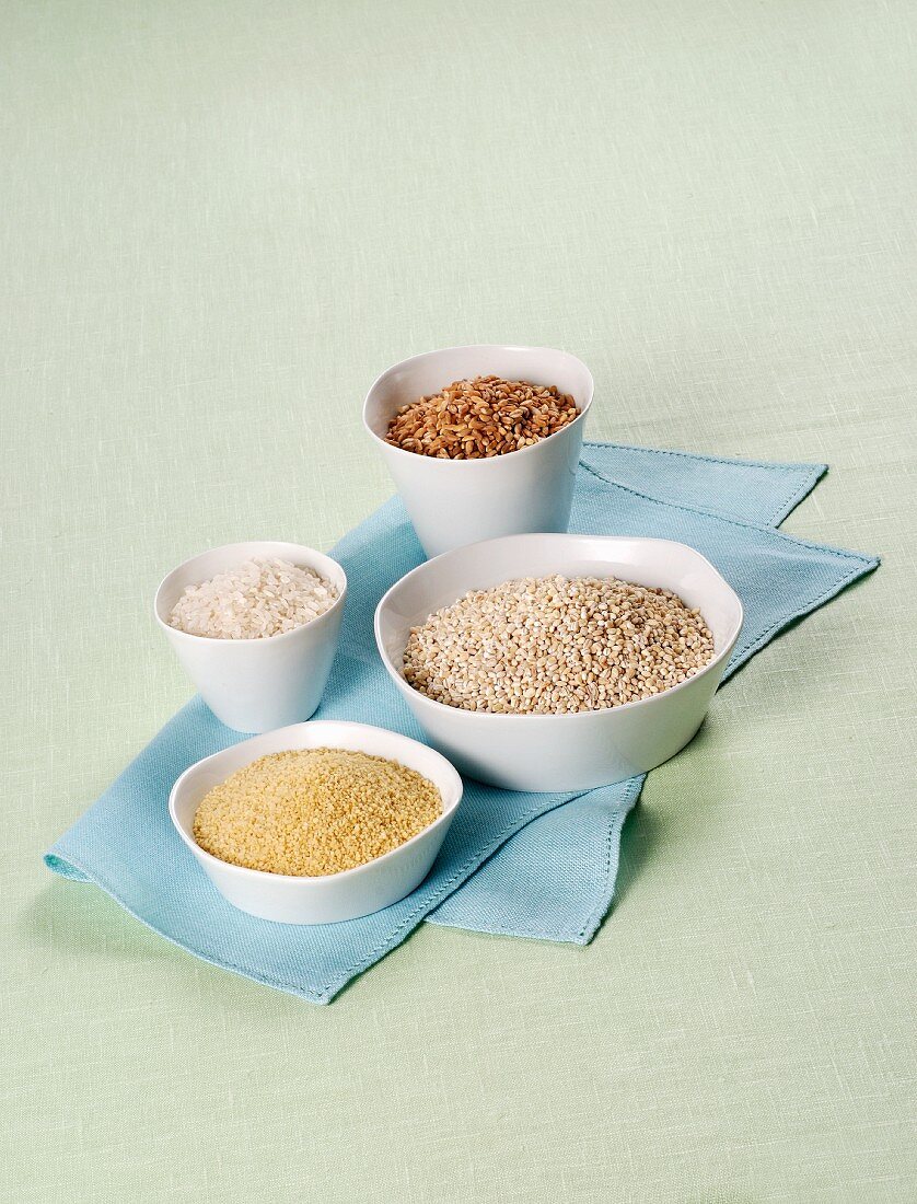 Rice, spelt, barley and couscous in white bowls