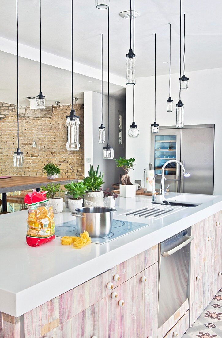 Pendant lamps made from recycled glass above kitchen counter